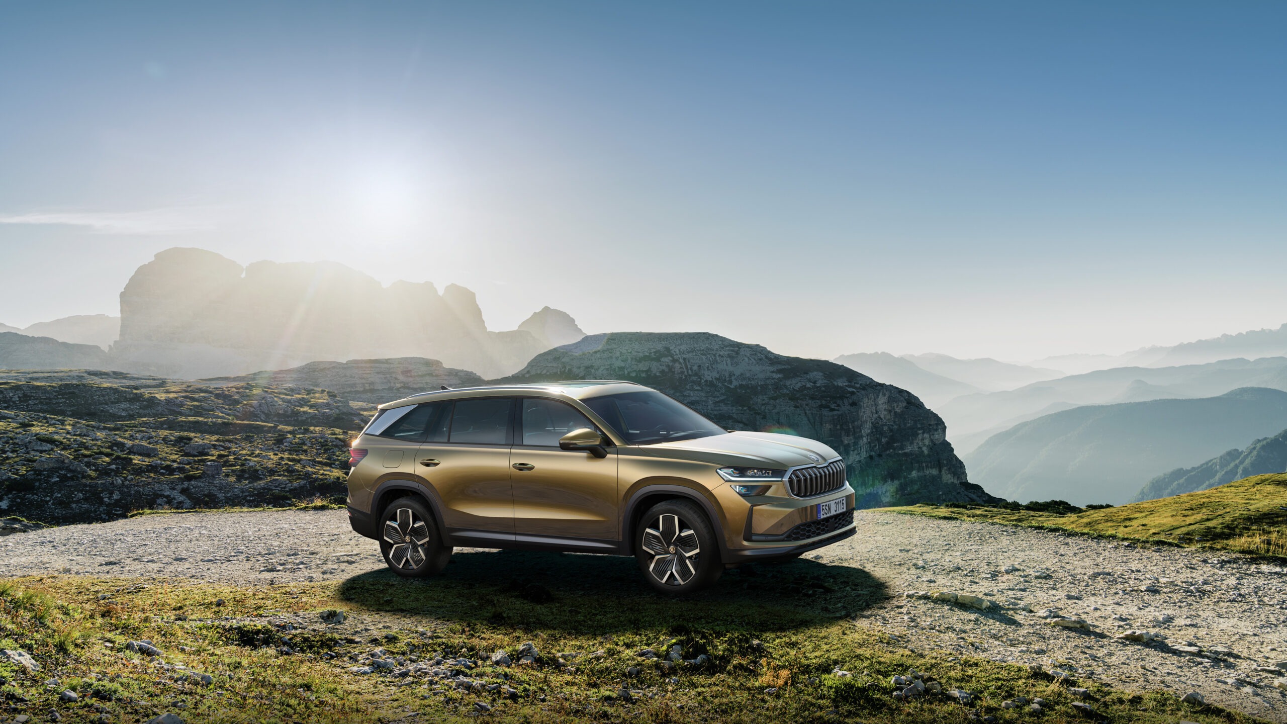 Kuldpruun Škoda Kodiaq seisab mägiteel päikesetõusu valguses